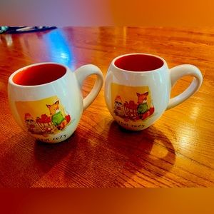 A pair of Rae Dunn coffee / tea mugs , fox and raccoon “stay cozy”